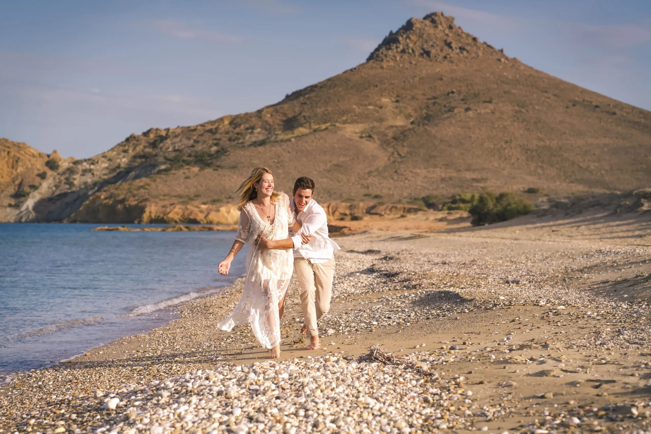 destination-engagement-photography-greece-couple-laughing-and-running-on-rocky-paros-beach